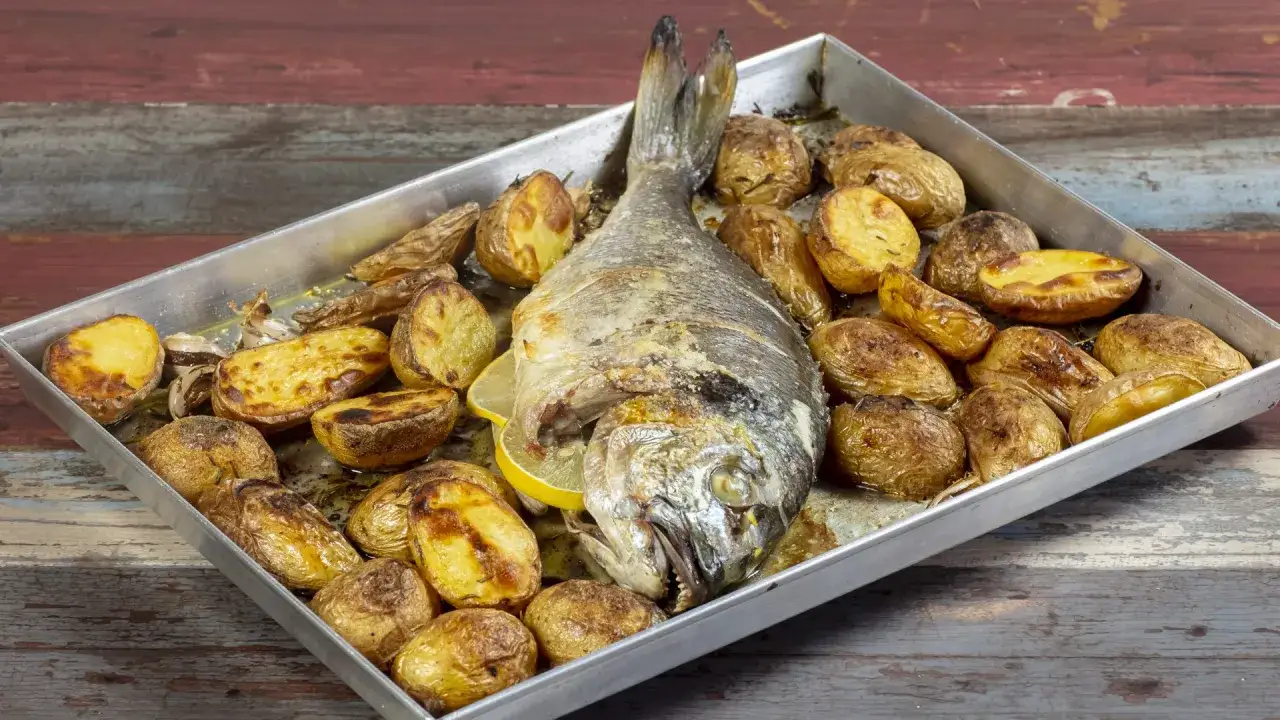 Orata al forno con patate arrosto, un piatto succulento e dorato, pronto per essere gustato.