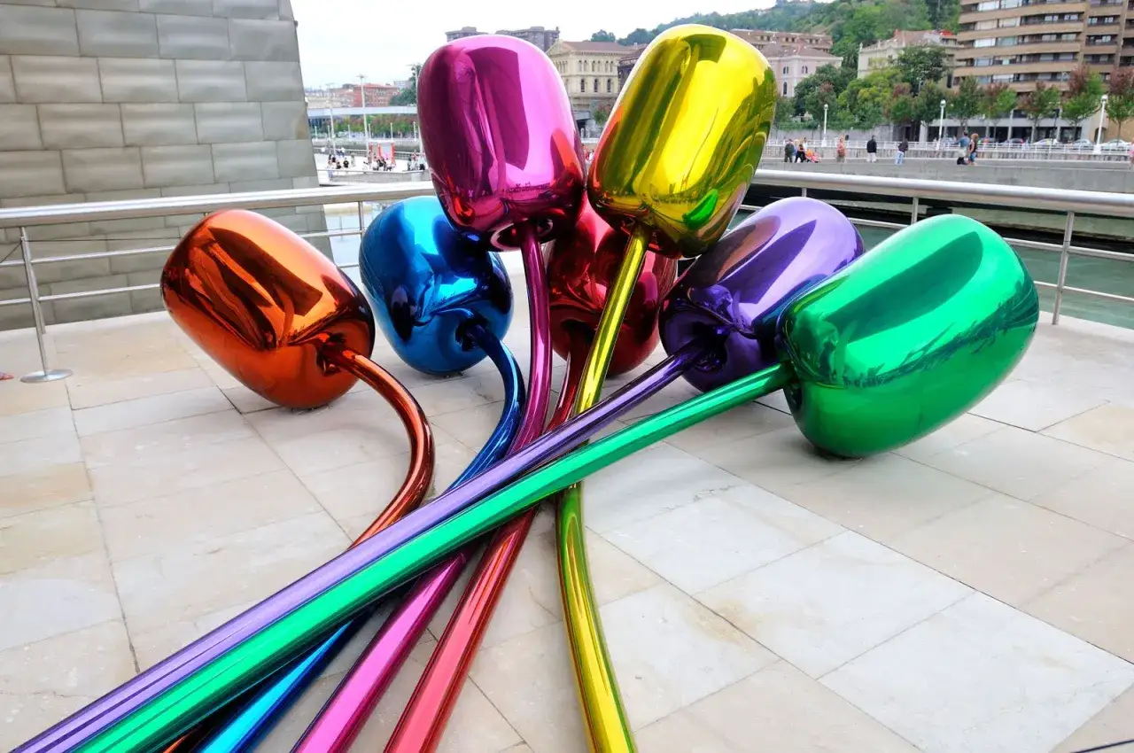 Jeff Koons-konstverk av gl&auml;nsande, f&auml;rgstarka ballongtulpaner som ligger utspridda p&aring; en stenlagd uteplats.