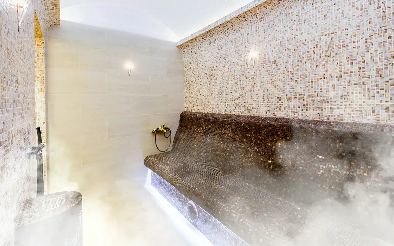 Ein luxuri&ouml;ses Hamam Dampfbad mit Mosaikfliesen und warmem Dampf.