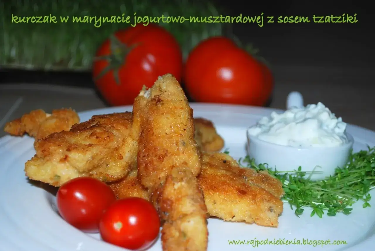 Chrupiące kawałki kurczaka w marynacie jogurtowo-musztardowej, podane z sosem tzatziki i pomidorkami. Idealne na obiad!