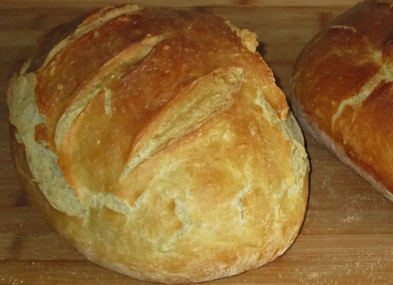 Dwa świeżo upieczone bochenki chleba na desce. Zastanawiasz się, jak długo piec chleb, by był idealny?