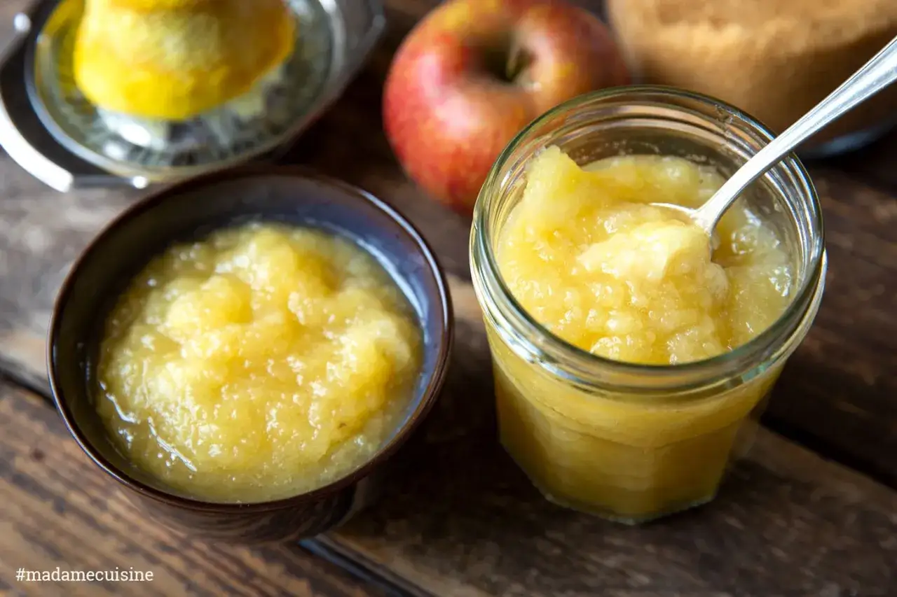 Hausgemachtes Apfelkompott, perfekt f&uuml;r Ihr n&auml;chstes Apfelkompott Rezept. Ein Glas und eine Schale voller goldener K&ouml;stlichkeit.