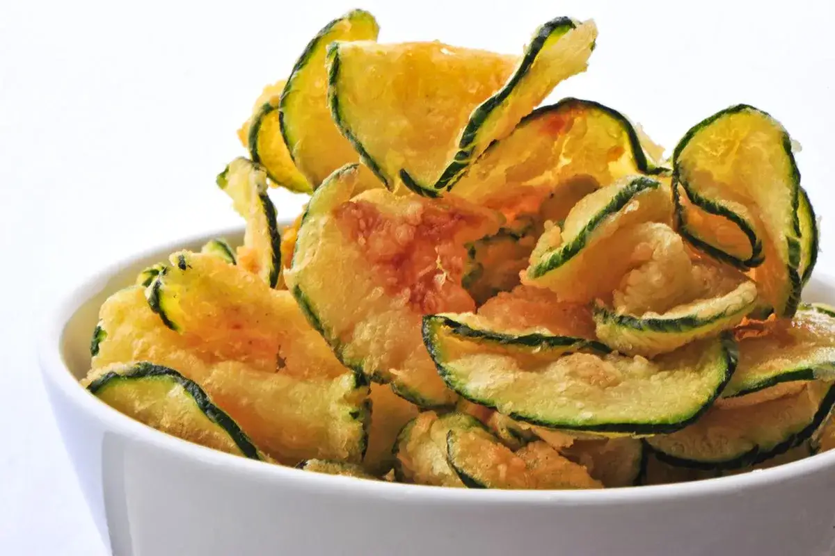 Fette croccanti di zucchine in friggitrice ad aria, dorate e pronte da gustare.