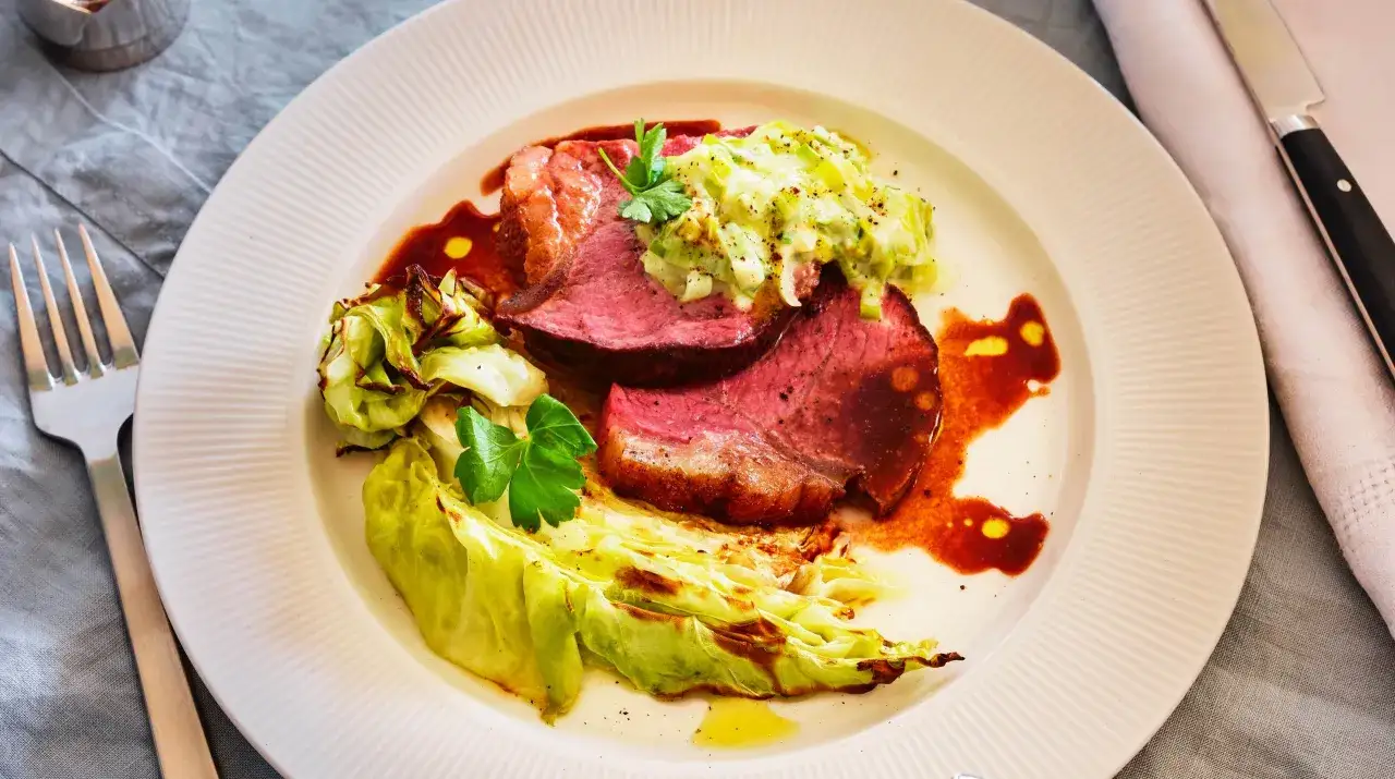 Saftig ryggbiff i ugn serverad med ugnsbakad vitkål och en krämig purjolöksröra.