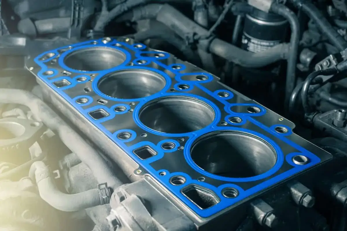 Una junta de culata nueva, con su borde azul, lista para sellar los cilindros del motor.