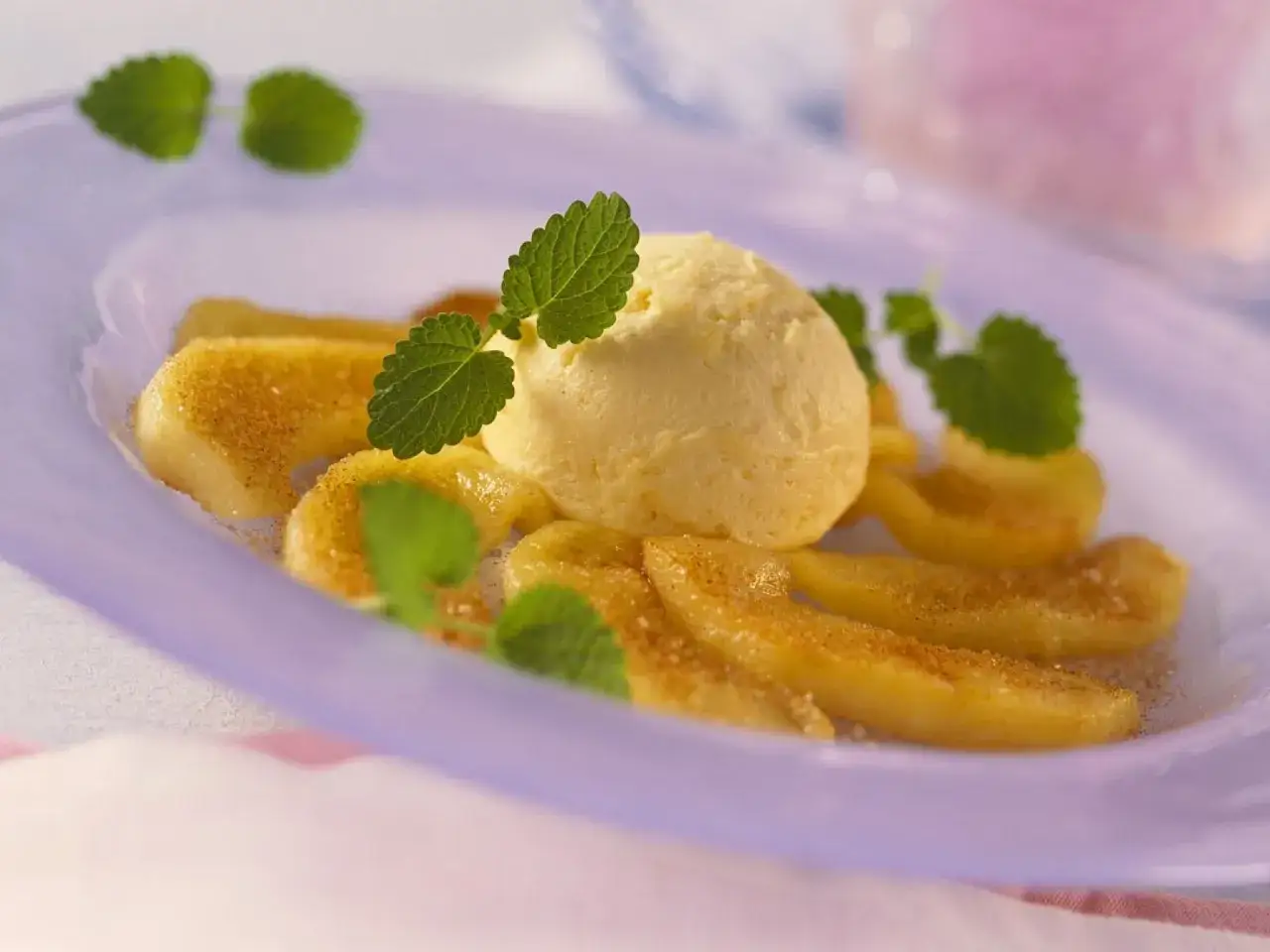 Ein L&ouml;ffel cremiges Eis auf karamellisierten Apfelspalten, garniert mit Minze. Vielleicht fragt man sich, warum gibt es kein Apfeleis, wenn &Auml;pfel so gut schmecken!