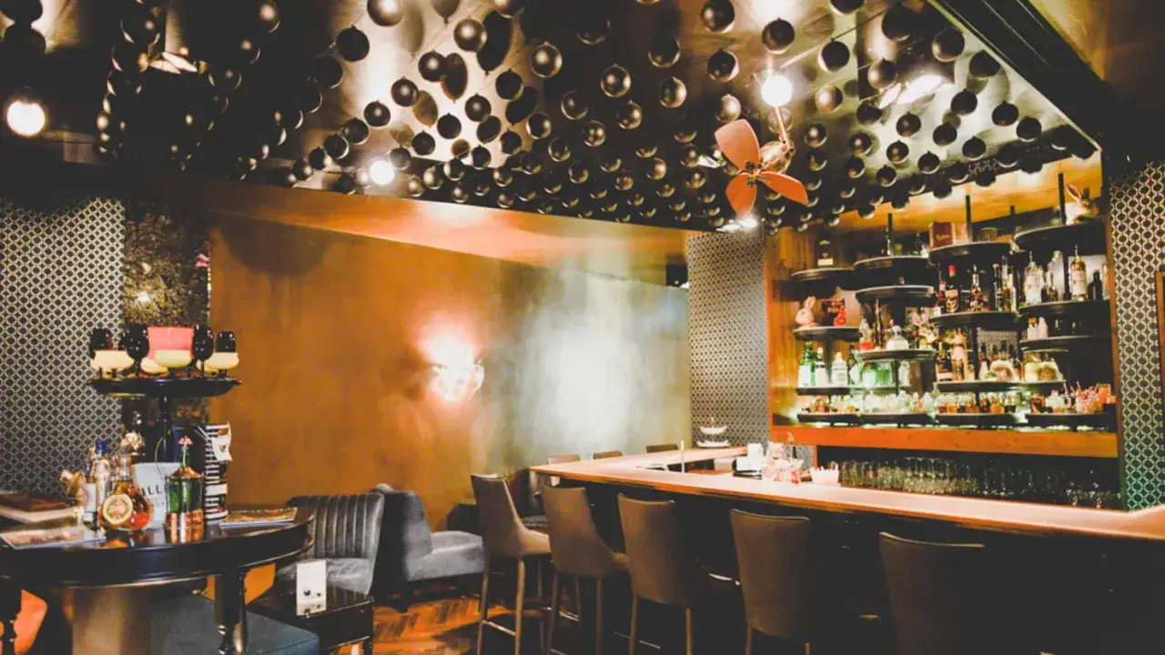 Stilvolle Bar mit vielen Kugeln an der Decke, die wie **Zimt und Zunder** gl&auml;nzen. Flaschenregale voller Spirituosen und bequeme Barhocker laden zum Verweilen ein.