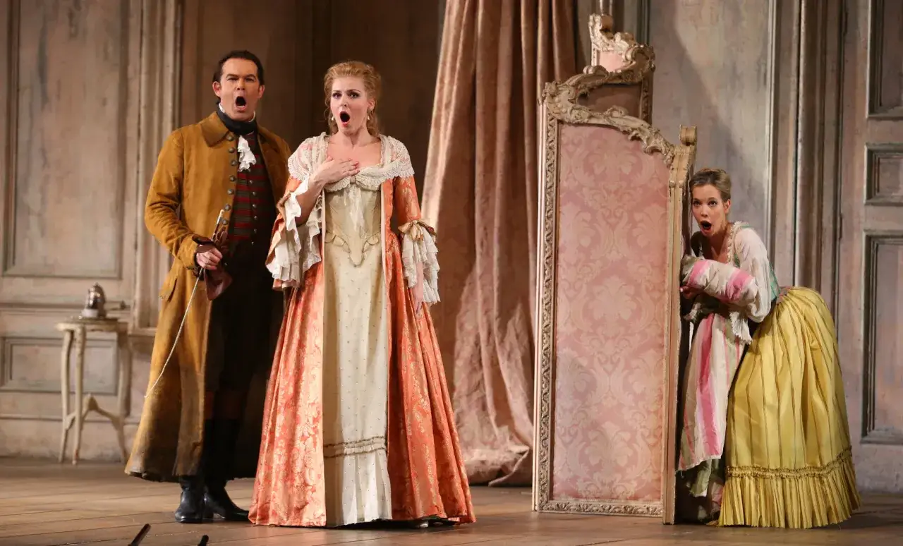 Opernsänger in historischen Kostümen, die eine Szene aus bekannten Werken von Mozart darstellen.
