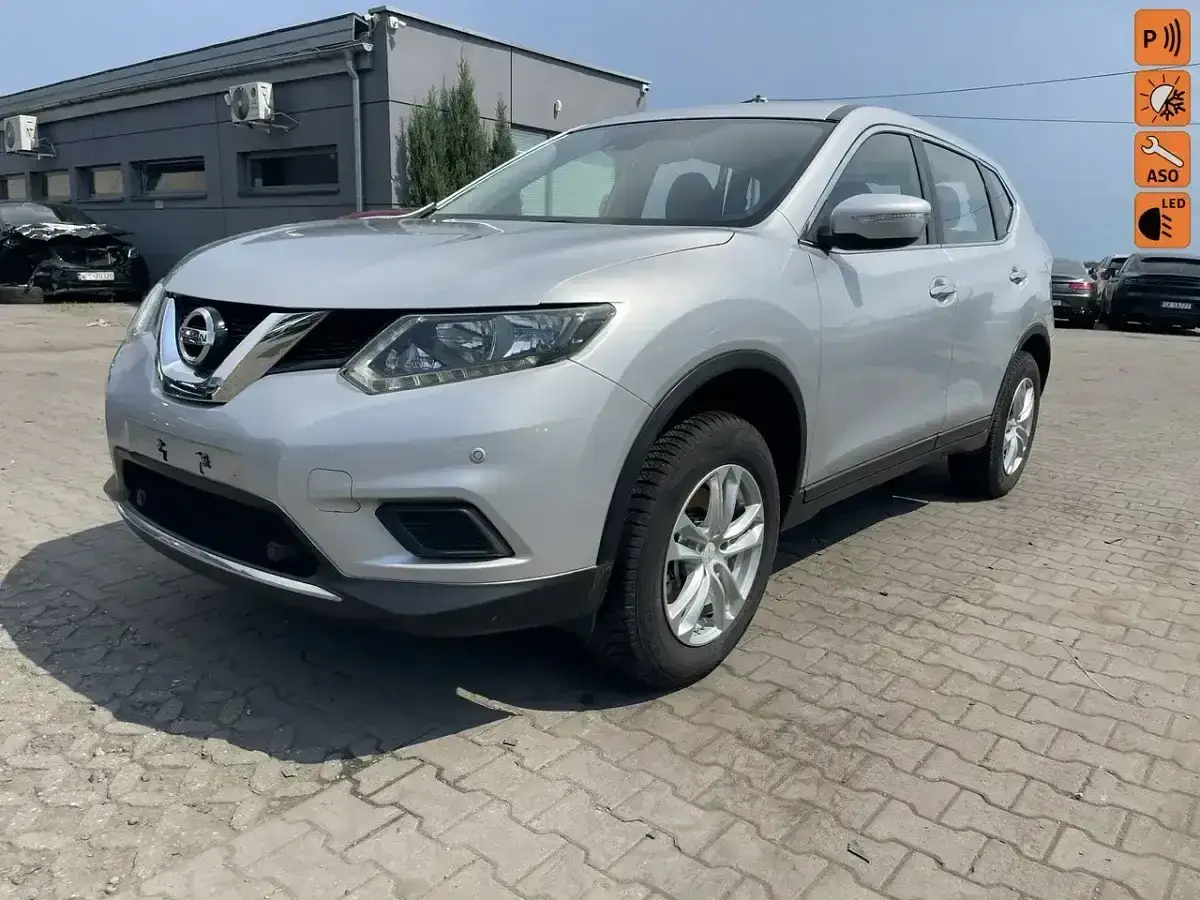 Srebrny Nissan X-Trail 2015 na placu, gotowy do jazdy.