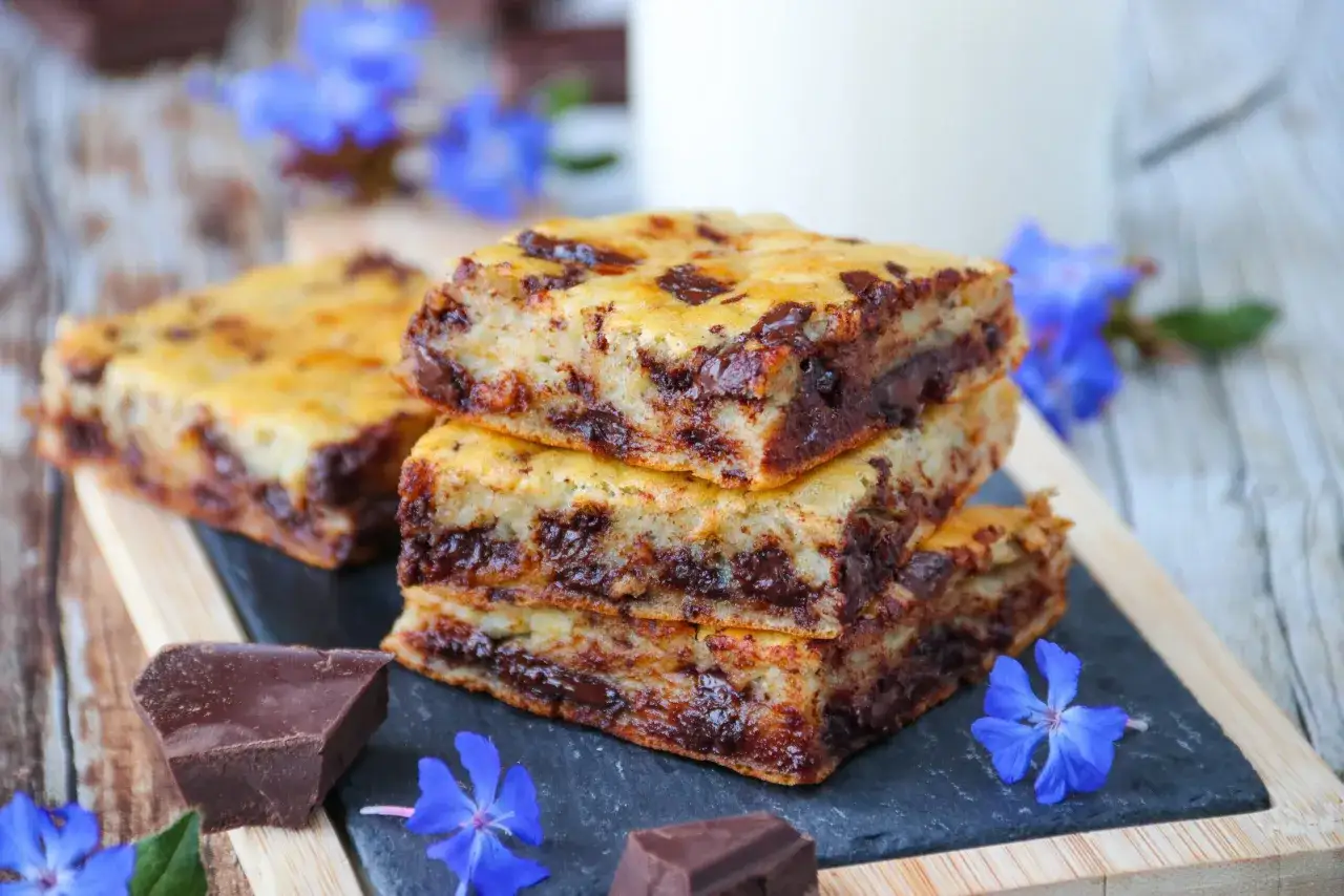 D&eacute;licieux g&acirc;teau banane chocolat, empil&eacute; avec des morceaux de chocolat noir et des fleurs bleues.