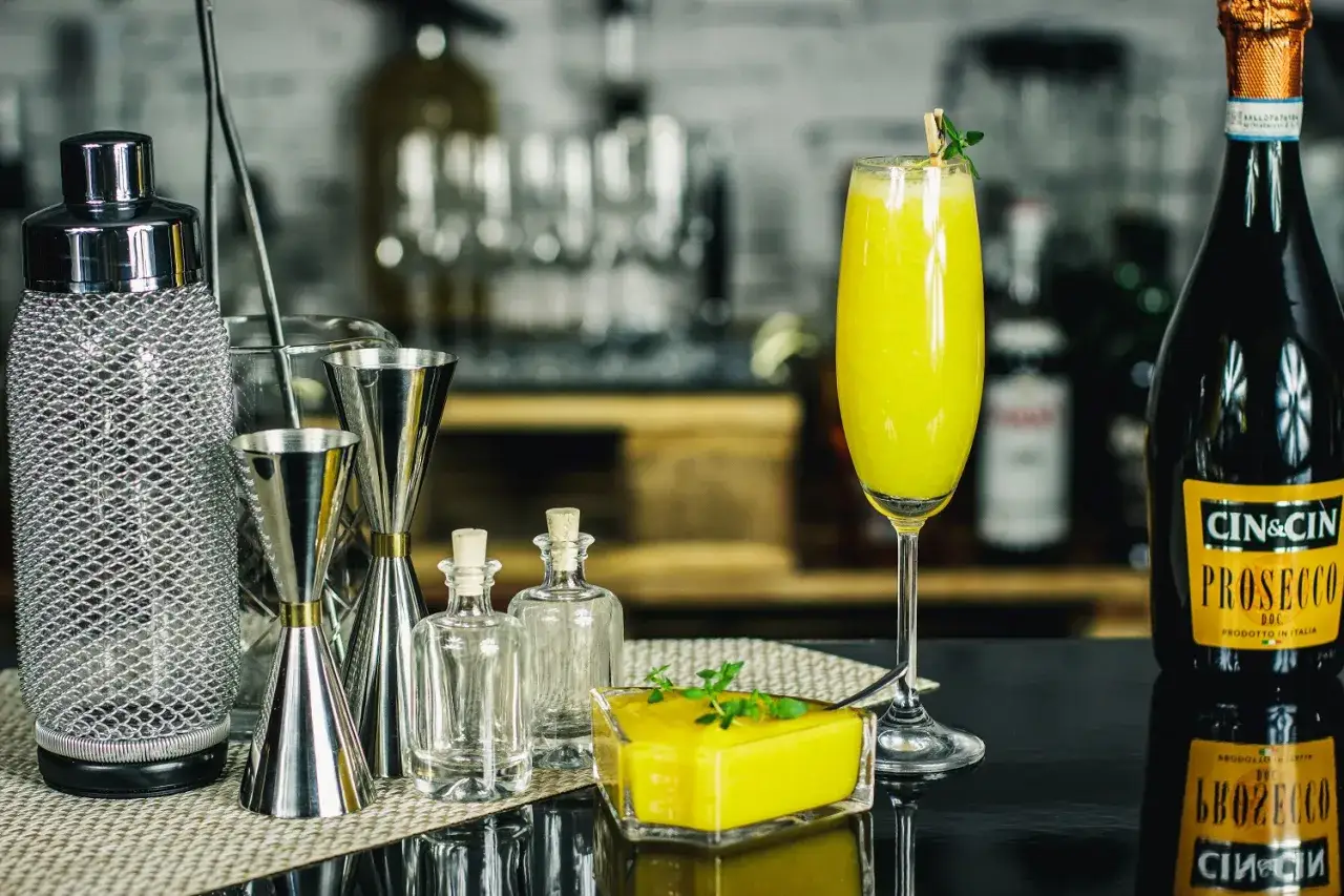 Barowe akcesoria i żółty drink z prosecco. Idealne drinki z prosecco czekają na przygotowanie.