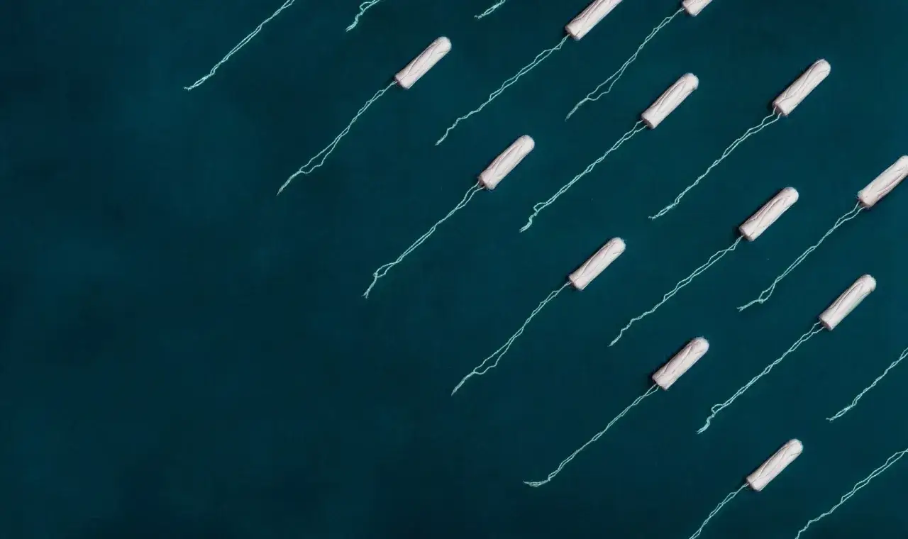 Wiele tamponów z nitkami na ciemnym tle. Czy można zajść w ciążę podczas okresu? To pytanie nurtuje wiele kobiet.