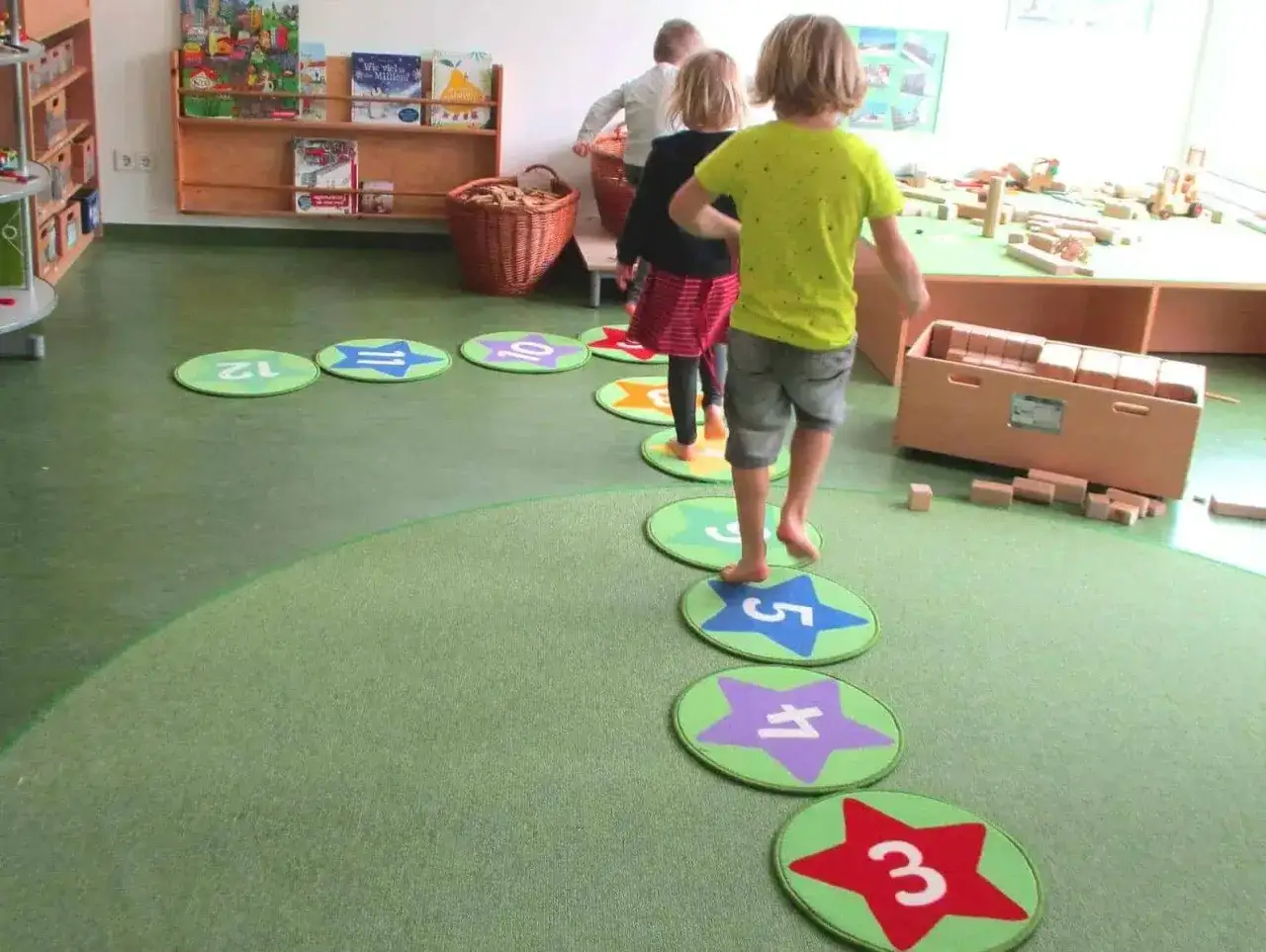 Kinder springen auf Zahlenmatten, die eine spielerische Einf&uuml;hrung in die **Mathematik im Kindergarten** darstellen.