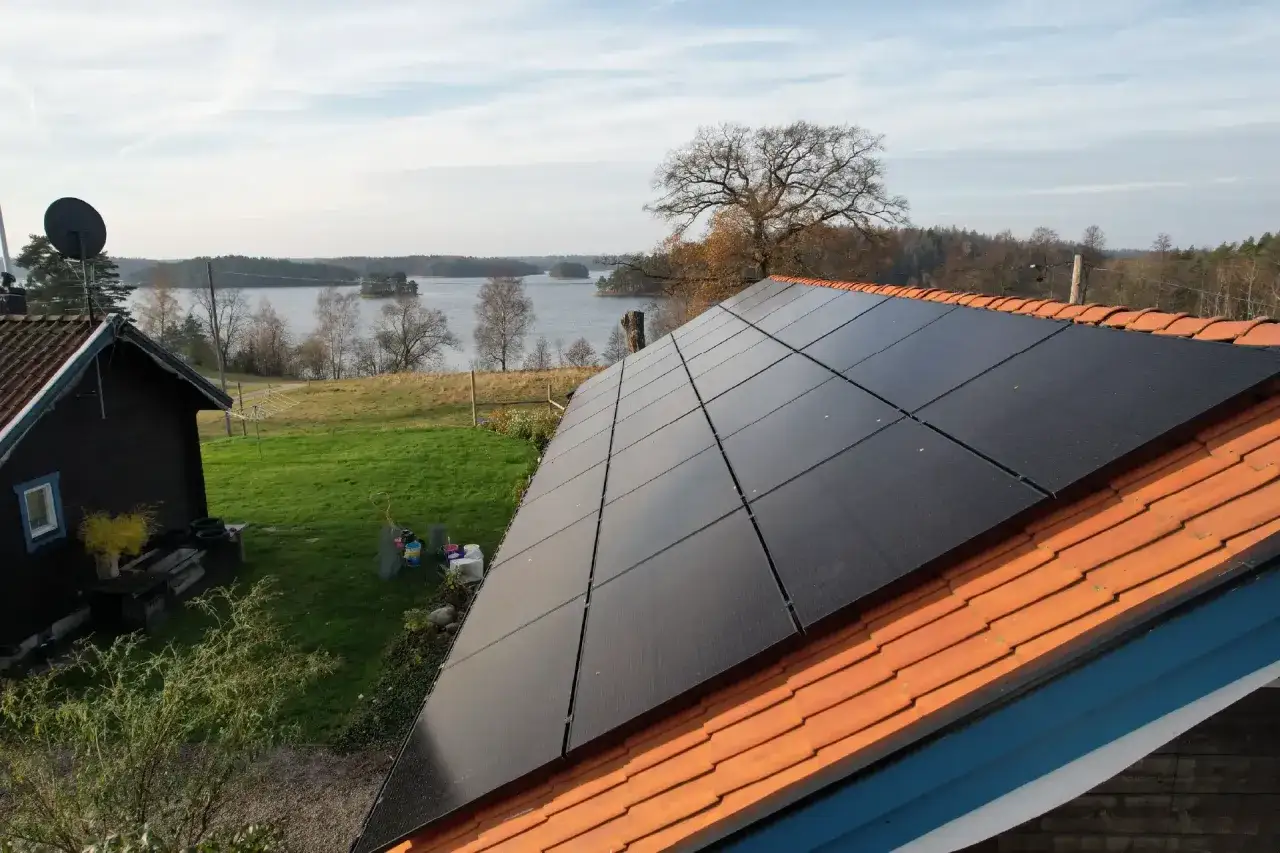 Solceller p&aring; taket vid en sj&ouml;. Bra solenergi f&ouml;r huset, som m&aring;nga solifokus recensioner bekr&auml;ftar.