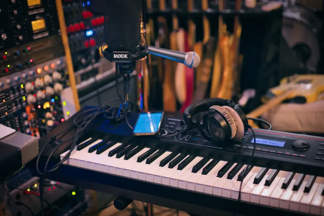 A studio setup with a keyboard, microphone, and headphones. This image hints at the tools and dedication needed for how to get in the music industry.