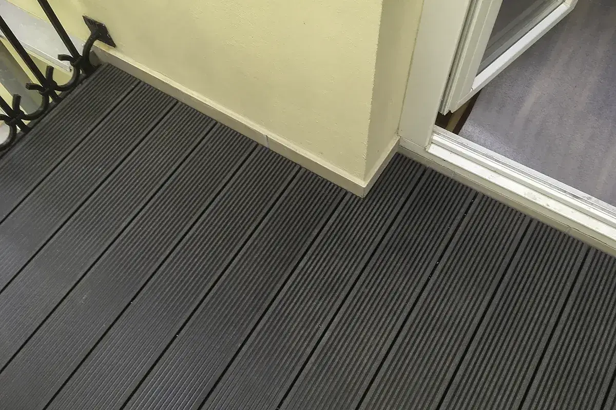 Nowy, tani balkonowy taras z ciemnych desek kompozytowych. Idealne rozwiązanie na balkon.