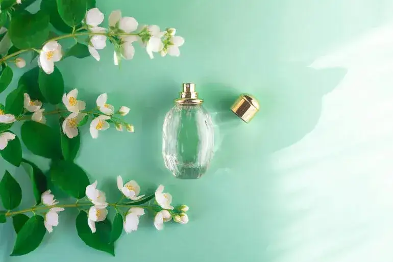 Flakons von Parfums mit Sandelholz und Jasmin auf elegantem Hintergrund