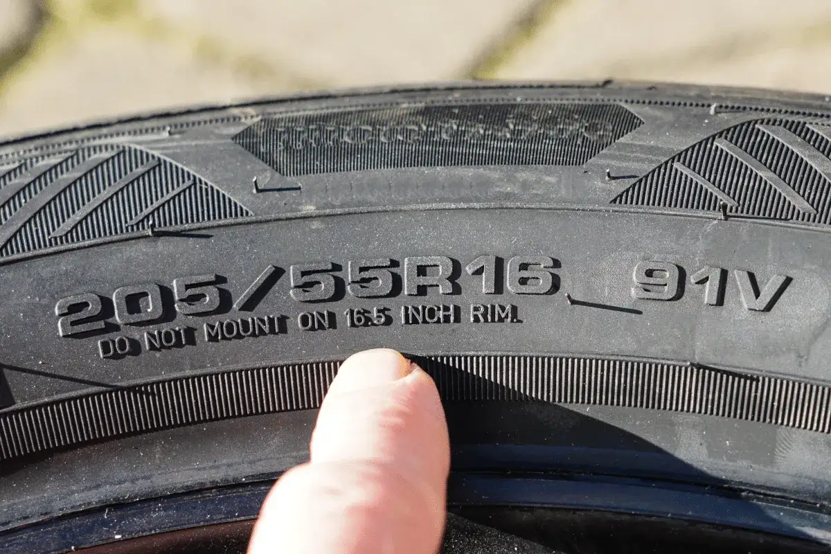Daumen zeigt auf die Reifengröße 205/55R16. So kann man die Zoll-Angabe am Reifen ablesen.
