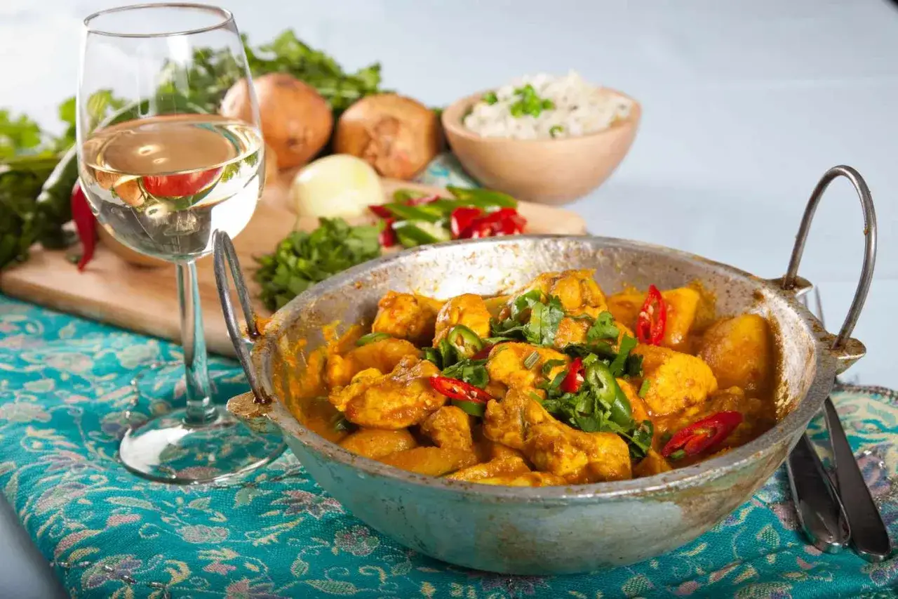 En smakrik kycklingcurry med ris, chili och koriander. Ett glas vitt vin till indisk mat &auml;r en perfekt kombination.