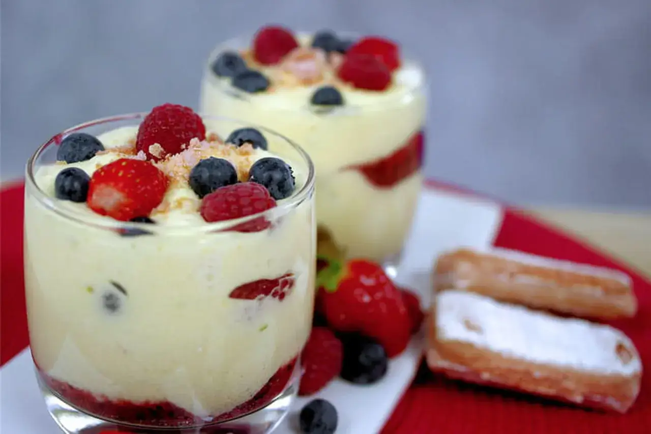 D&eacute;licieux tiramisu fruits &eacute;t&eacute;, garni de framboises, myrtilles et fraises, servi dans des verres.