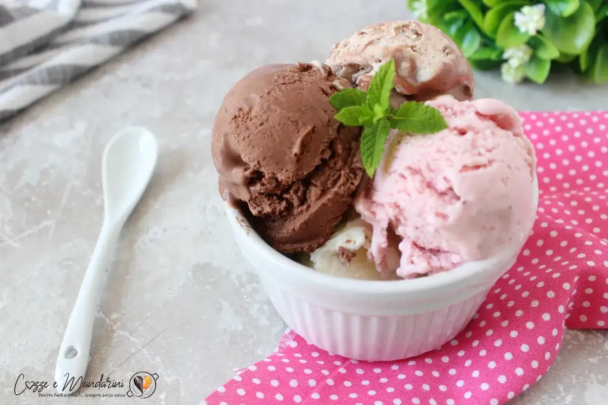 Coppa di gelato fatto in casa con gusti cioccolato, fragola e vaniglia, guarnita con menta fresca.