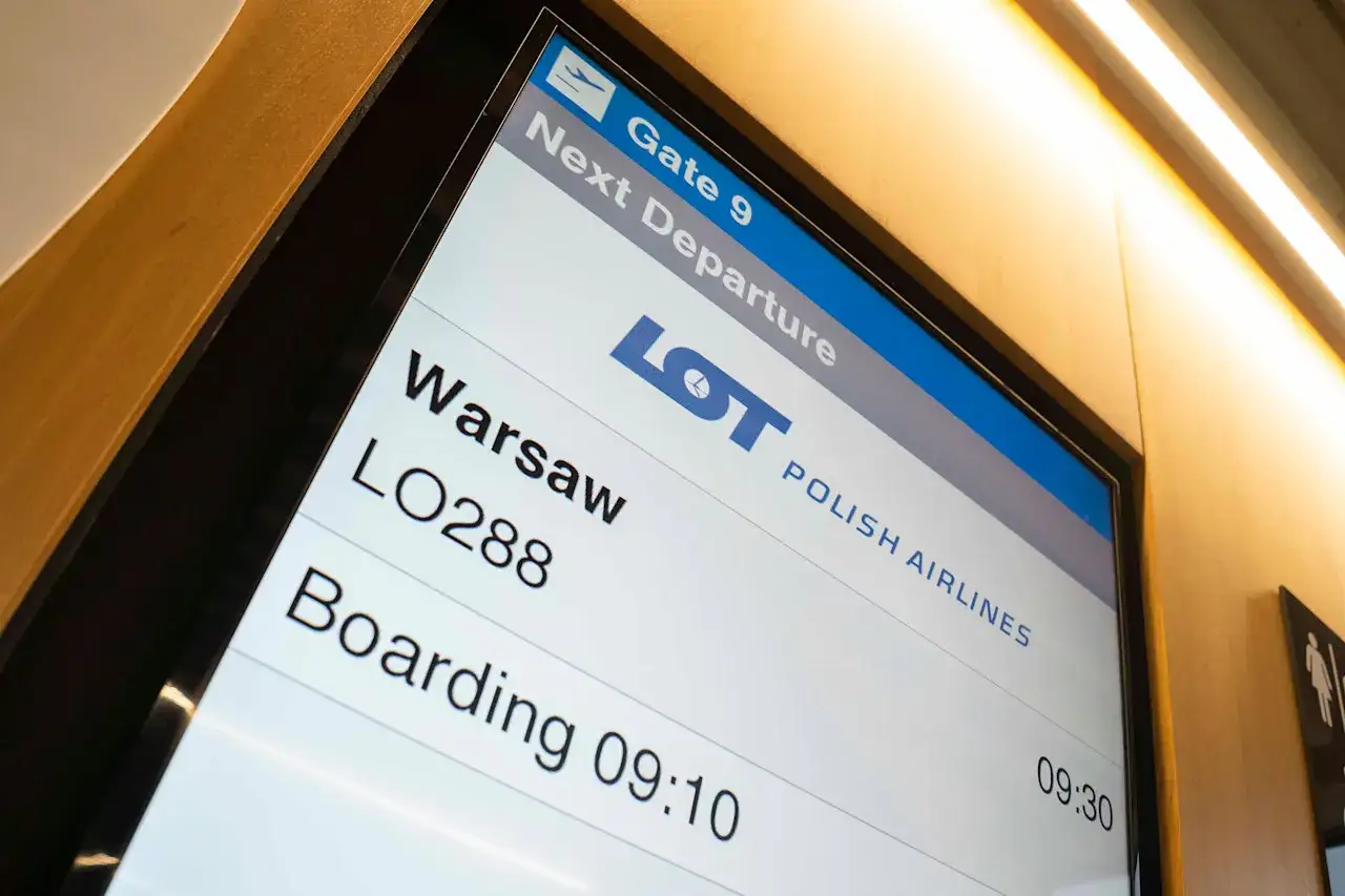 Tablica odlotów LOT-u: Warszawa LO288, bramka 9, boarding 09:10. Czas na bilety do Anglii!