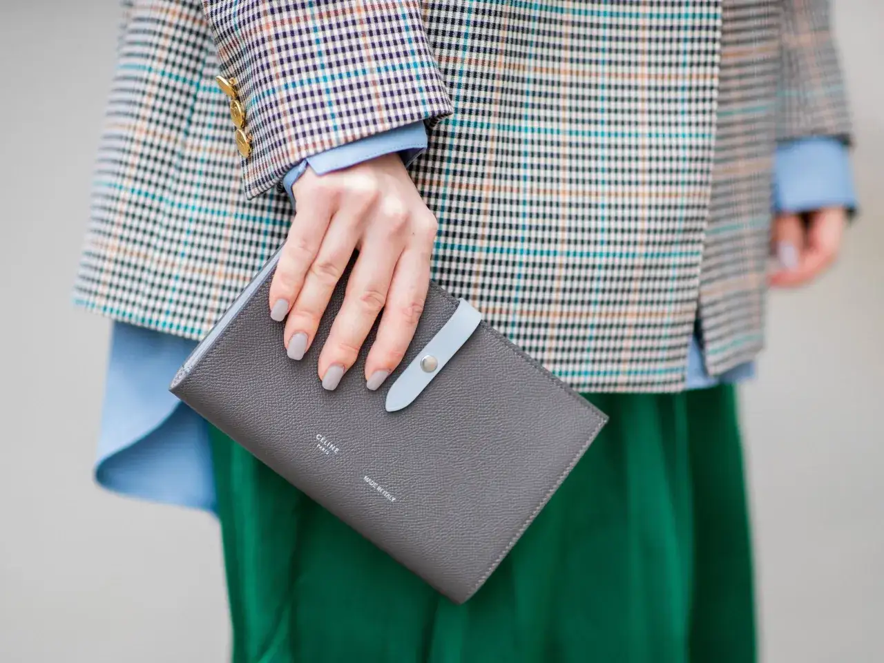 Manicure grigia in tono con la borsa, un'idea su come abbinare lo smalto ai vestiti con un blazer a quadri e gonna verde.