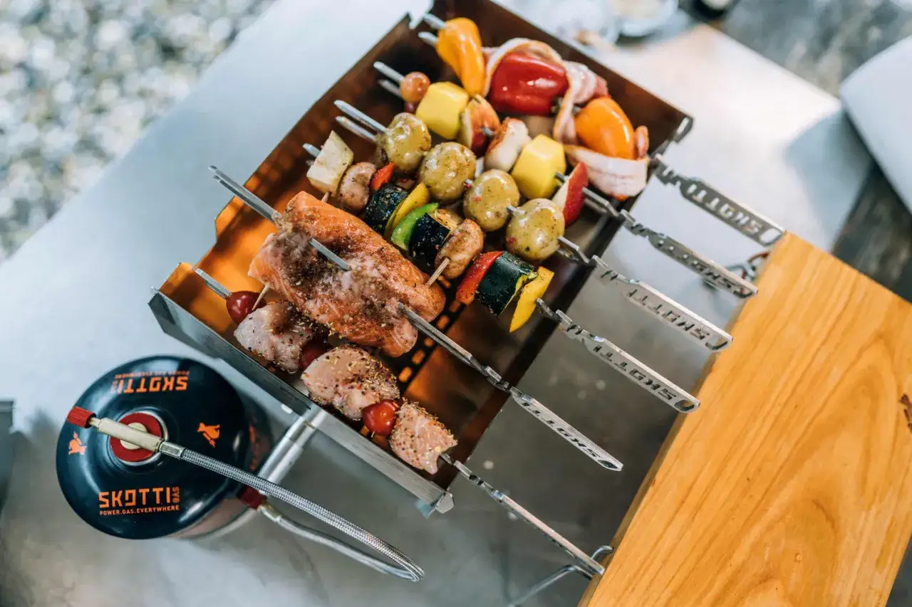 Pyszne szaszłyki z łososiem, kurczakiem i warzywami gotowe do grillowania. Obok butla gazowa SKOTTI.