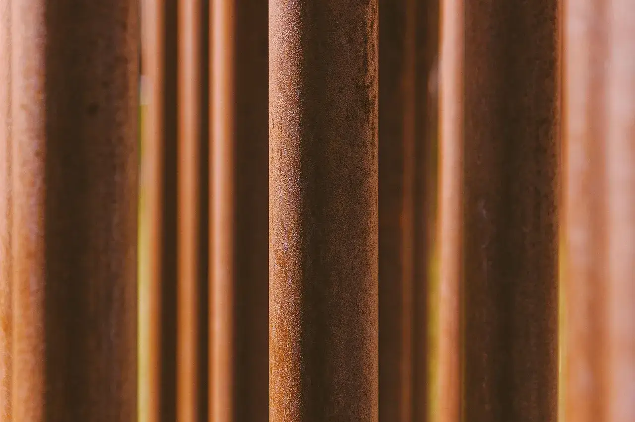 Rdzewiejące pionowe słupki, przypominające naturalnie patynowany metal. Zastanawiasz się, jaka farba do metalu da taki efekt?