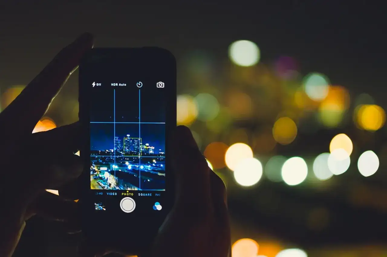 Maintenant, je vais prendre une photo avec mon portable de cette magnifique vue nocturne de la ville.