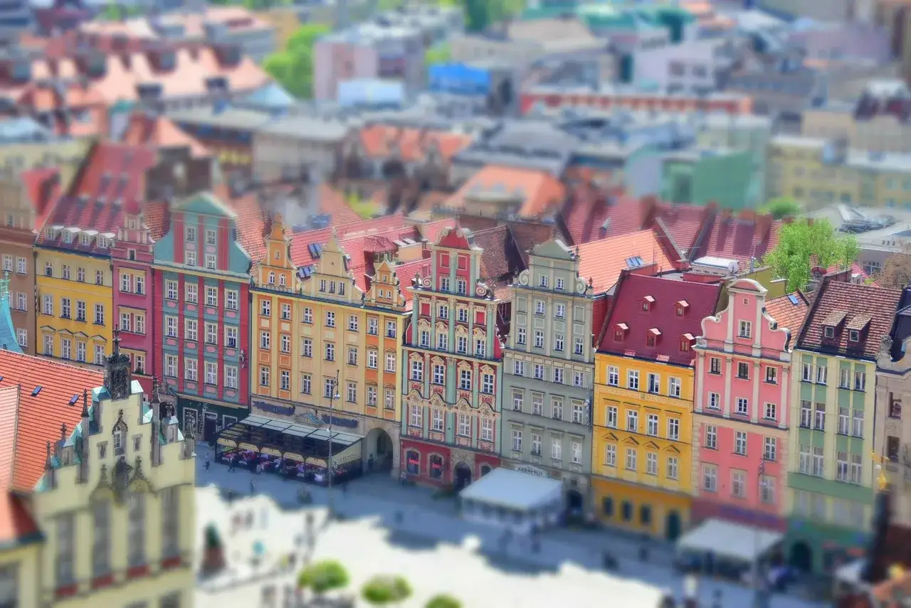 Kolorowe kamienice na starym rynku we Wrocławiu, z widokiem na dachy i plac.