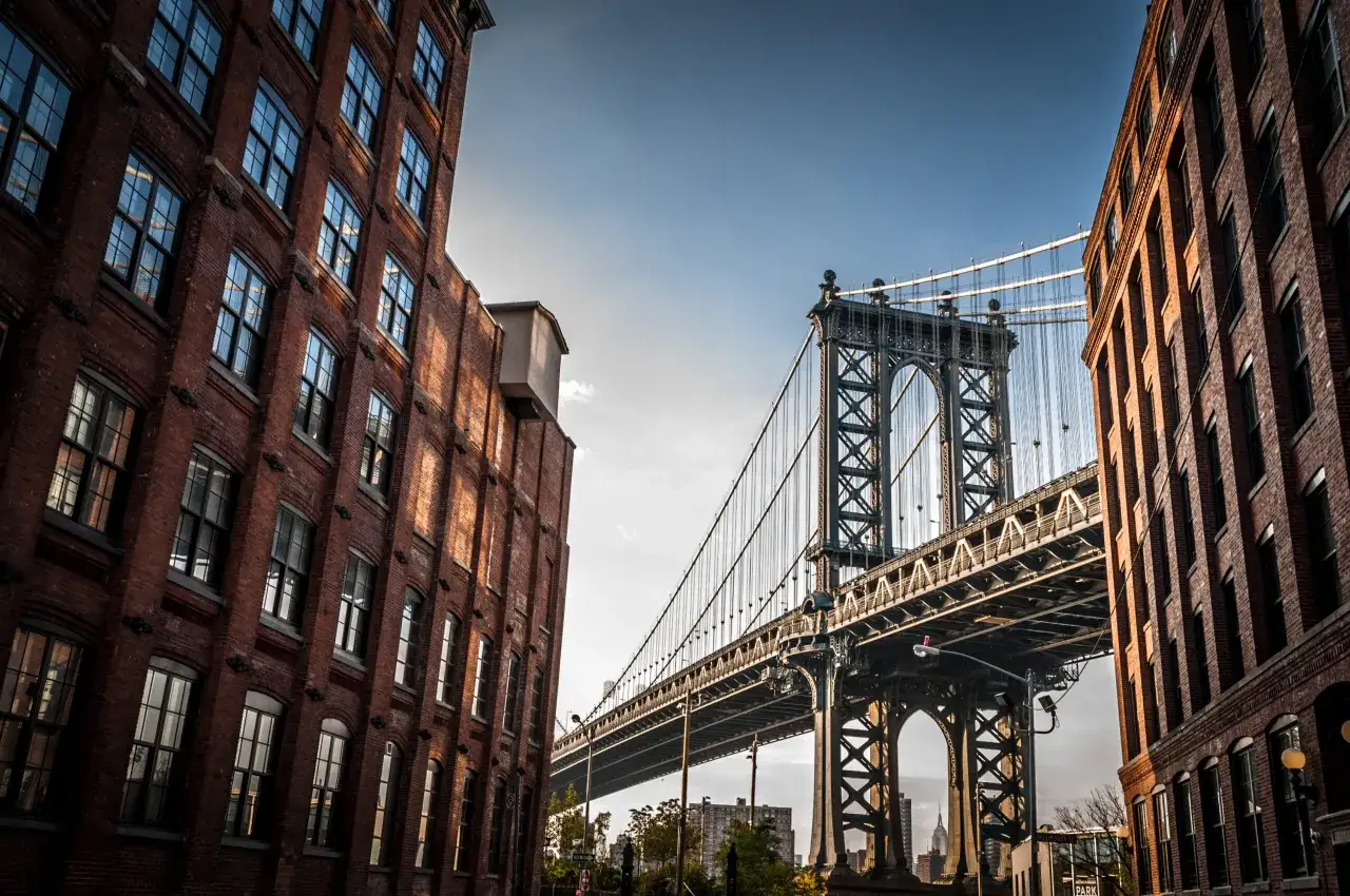 Ceglane budynki i majestatyczny most Manhattan w Nowym Jorku. Czy Brooklyn jest bezpieczny? Widok sugeruje spokój i piękno.