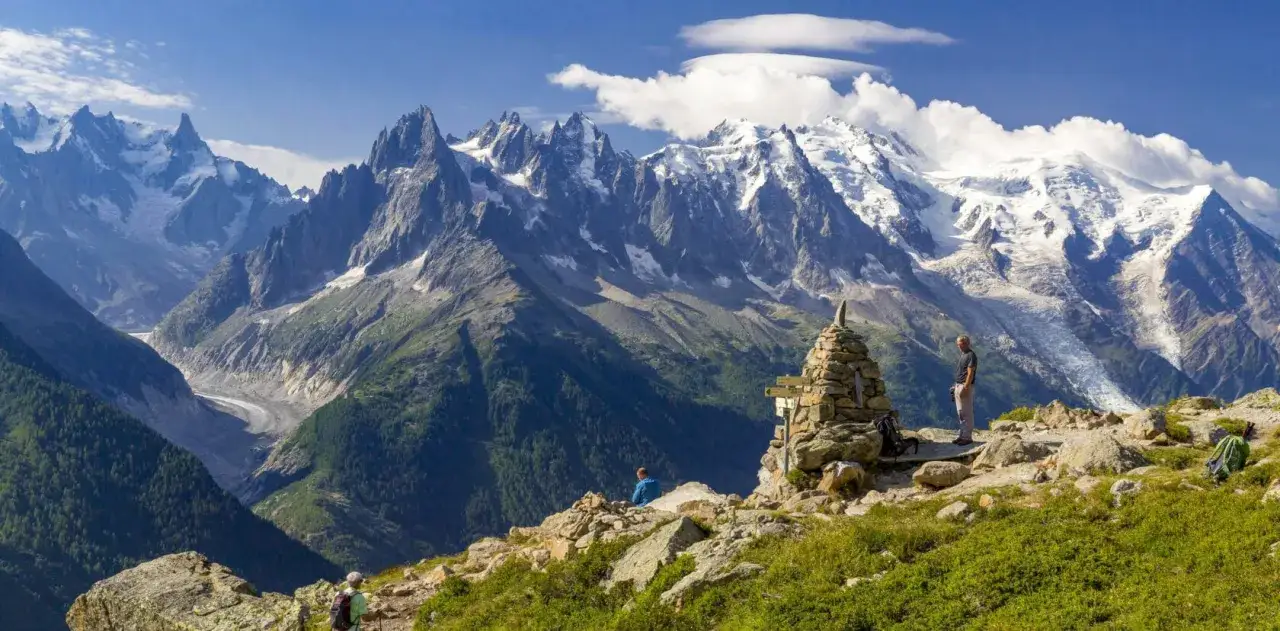 Widok na majestatyczne Alpy, szlak Haute Route. Turyści podziwiają lodowiec i ośnieżone szczyty.