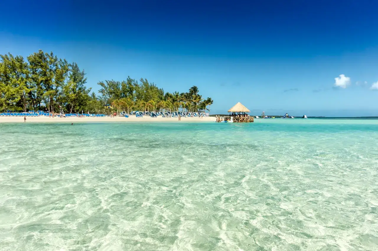 Türkisblaues Meer, Palmen und Liegestühle – perfekte Reiseziele im November für sonnige Tage am Strand.