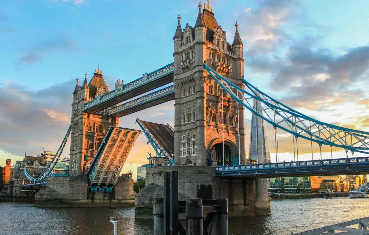 Torre de Londres con sus brazos levantados, mostrando la majestuosidad de sus puentes levadizos al atardecer.