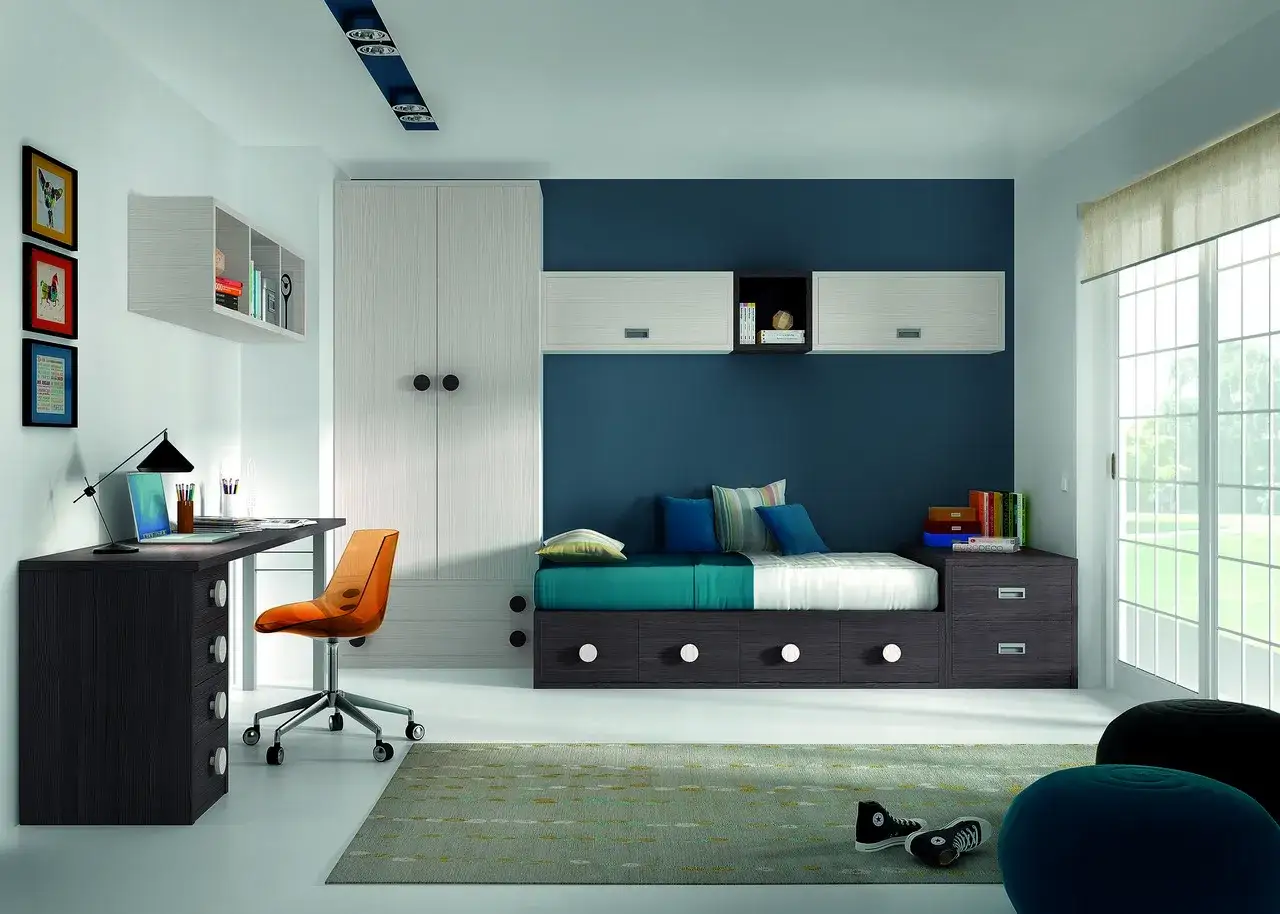 Habitaci&oacute;n juvenil moderna con cama, escritorio y armario. La pared azul es ideal para la pintura de habitaciones juveniles.