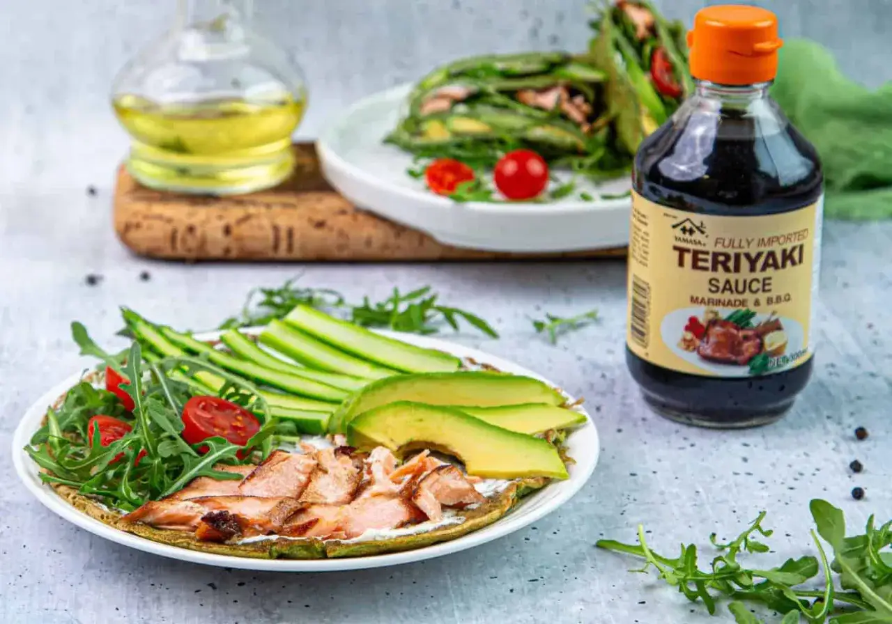 Pyszna propozycja co na kolację: łosoś z awokado, rukolą i ogórkiem na placku. Obok sos teriyaki.