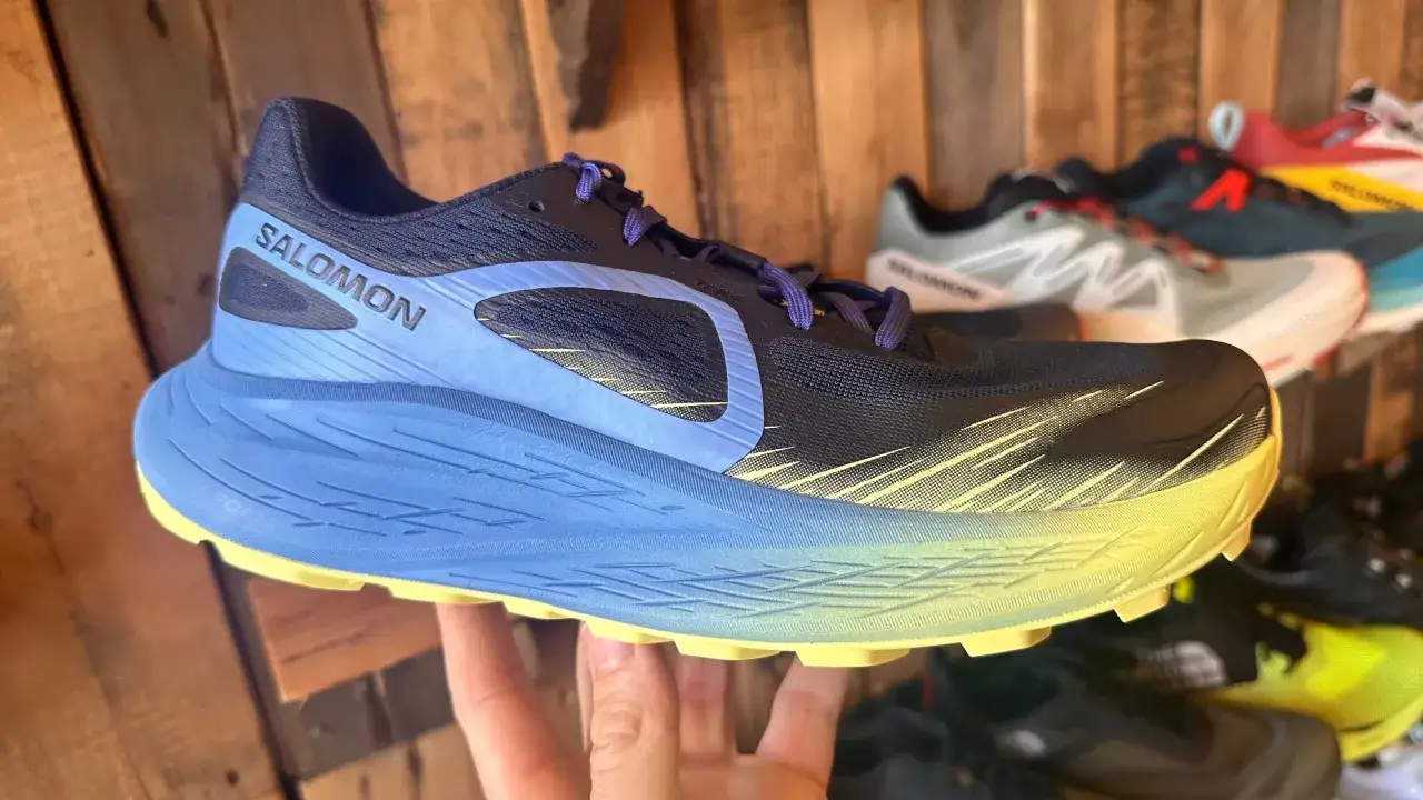 Chaussure Salomon noire et bleue, avec une semelle épaisse jaune et bleue, offrant le hoka meilleur amorti pour vos courses.