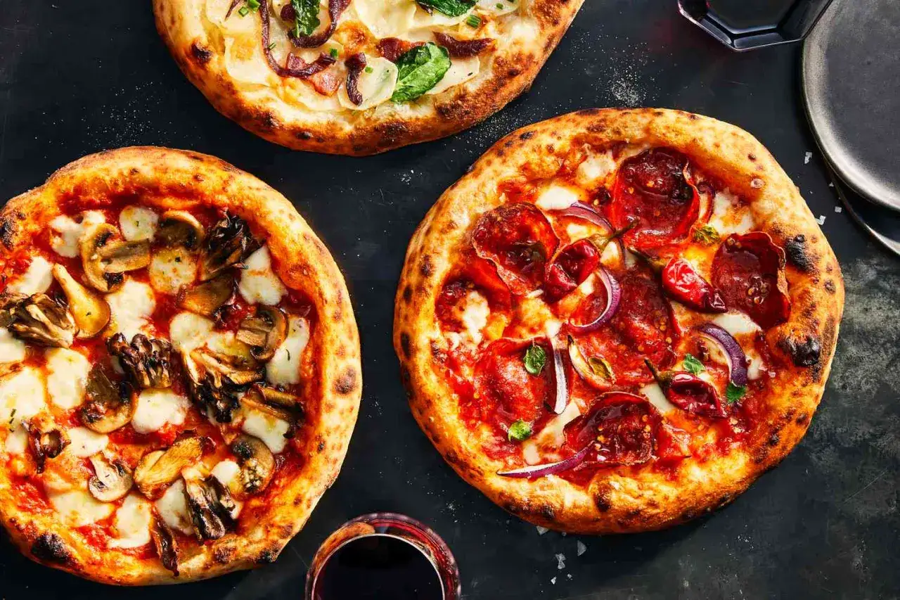 Trzy pyszne pizze: z grzybami i mozzarellą, pepperoni i cebulą, oraz biała z warzywami. Idealne składniki na pizzę dla każdego smakosza.