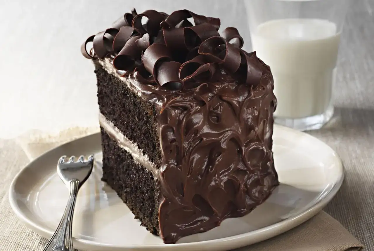 Une part de gâteau banane chocolat, riche et onctueuse, garnie de copeaux de chocolat. Un délice à savourer avec un verre de lait.