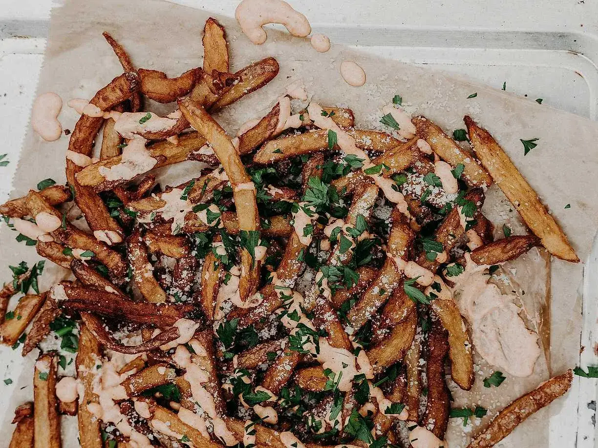 Krispigt fritera pommes med persilja och en krämig sås. Perfekt tillbehör!