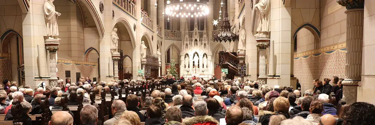Menschen versammeln sich in einer Kirche für eine Feier zum Reformationstag. Ein Chor singt vor dem Altar, während die Gemeinde aufmerksam zuhört.