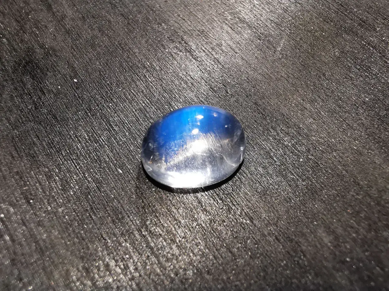 Pietra di luna con riflessi blu intensi, che evoca le sue propriet&agrave; mistiche e calmanti.