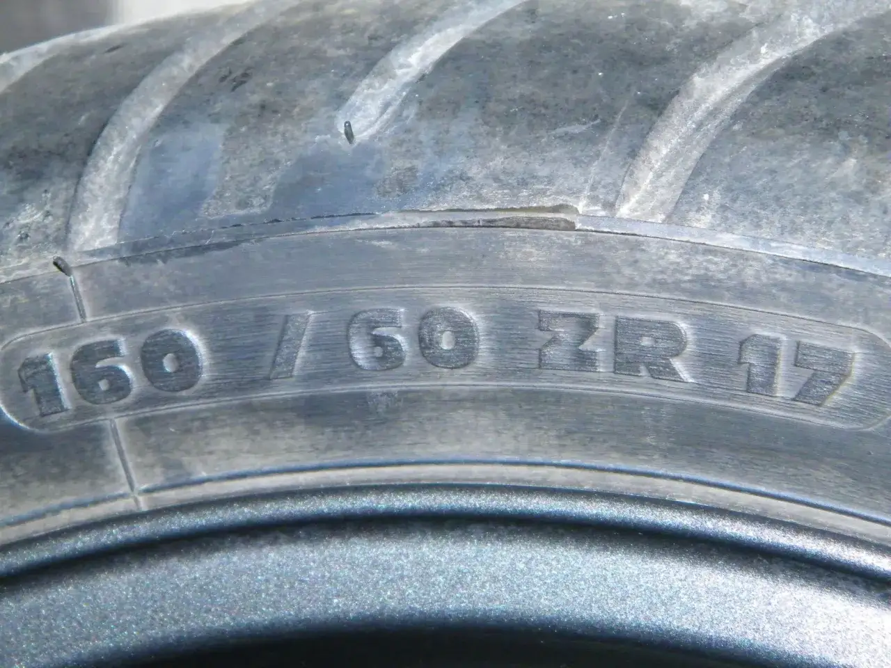 Zbliżenie na bieżnik opony z oznaczeniem 160/60 ZR 17.