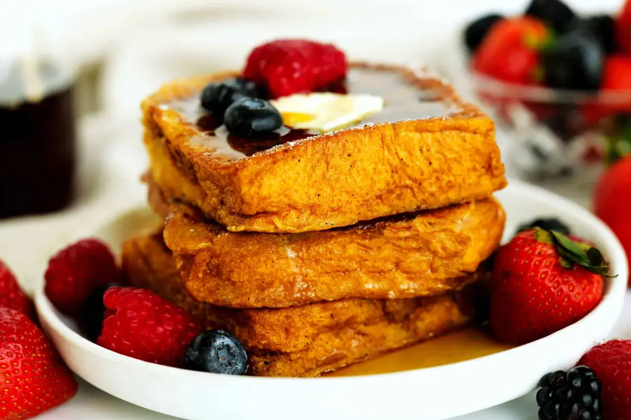 Gestapelte Brioche French Toast mit Beeren und Sirup. Ein k&ouml;stlicher Start in den Tag!