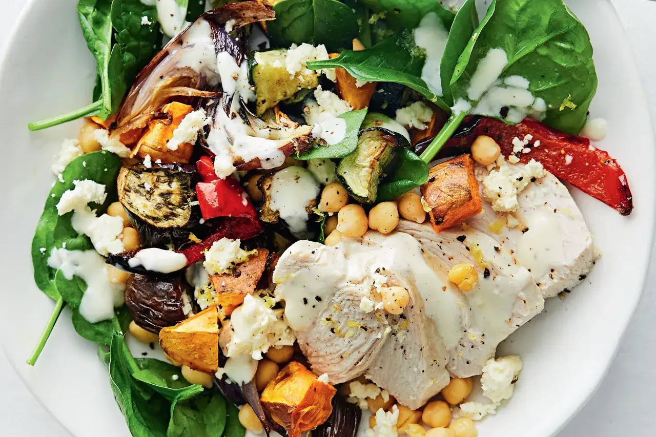 En matig sallad med kyckling, rostade gr&ouml;nsaker som s&ouml;tpotatis och aubergine, kik&auml;rtor och fetaost, toppad med en kr&auml;mig dressing.