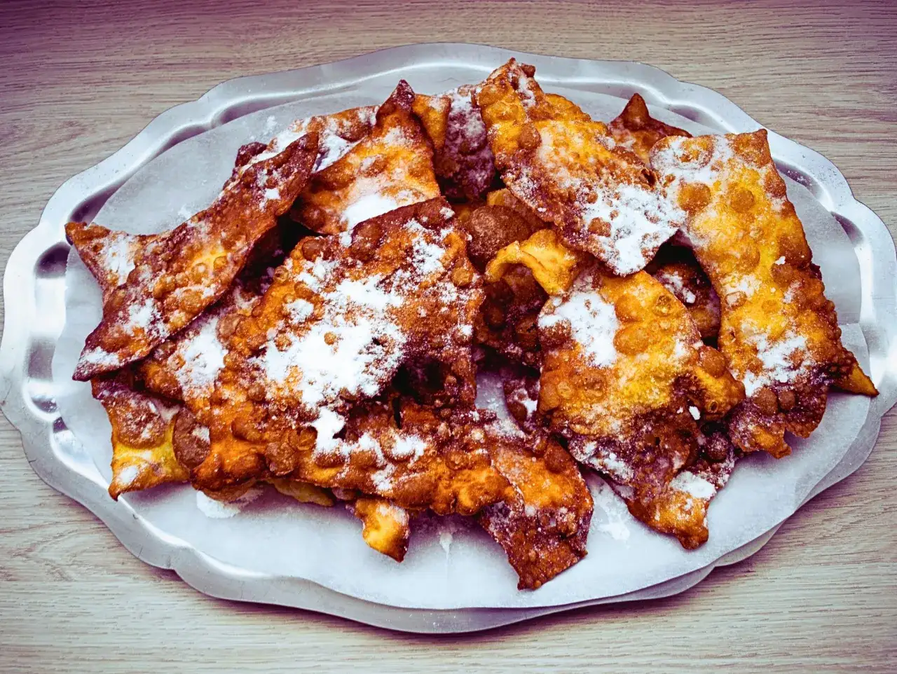 Orejas de carnaval crujientes y doradas, espolvoreadas con azúcar glas. Una deliciosa receta para disfrutar en fiestas.