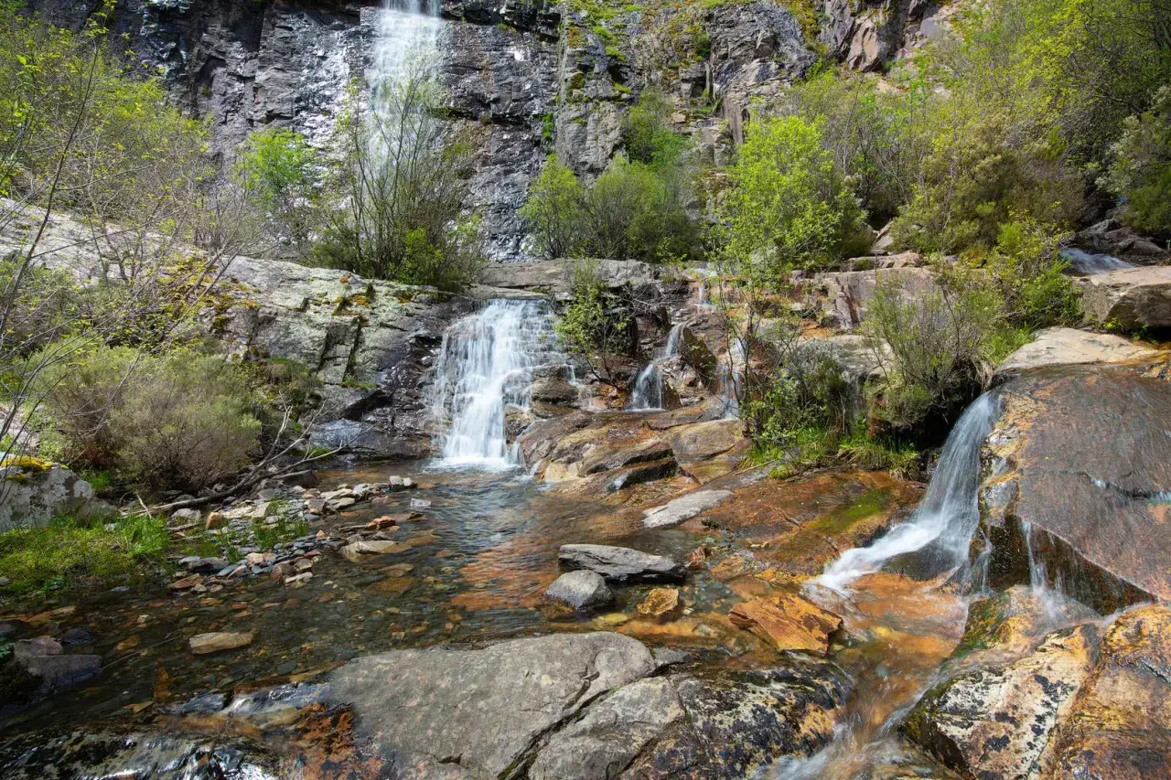 Las chorreras de despeñalagua, un espectáculo natural de cascadas y rocas, donde el agua desciende entre la vegetación exuberante.