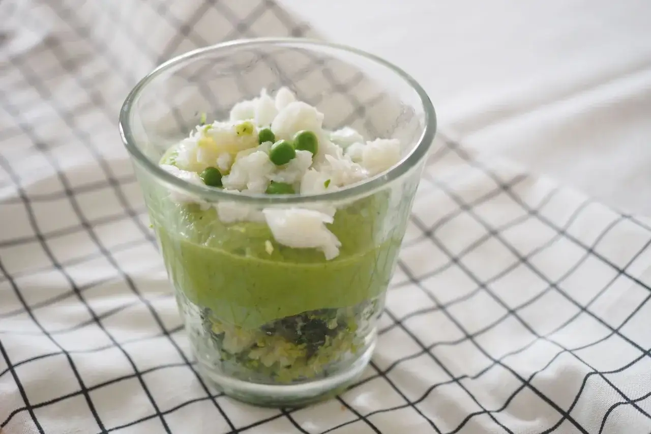 Verre de purée verte avec du cabillaud effiloché et des petits pois. Une recette cabillaud enfant facile et colorée.
