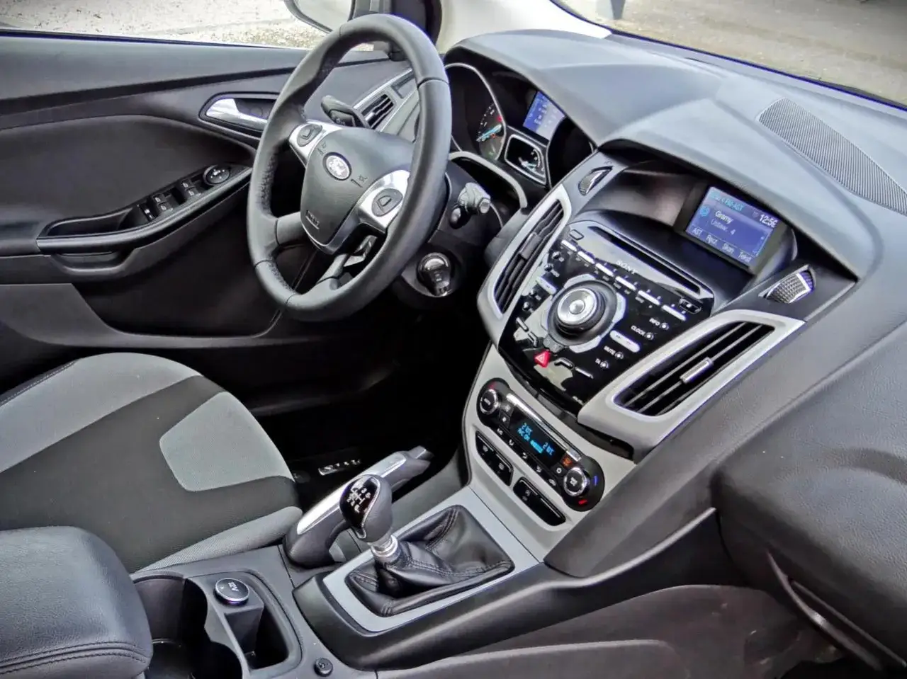 Wnętrze Forda Focusa MK3. Kierownica, deska rozdzielcza z radiem Sony i ekranem, dźwignia zmiany biegów. Wiele osób chwali to auto w swoich **ford focus mk3 opinie**.